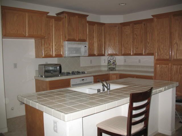 1233 Broken Spur Way, Plumas Lake, CA - Kitchen with Island Sink and Tile Countertops
